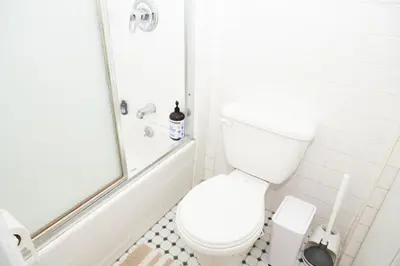 a white bathroom with a toilet and a shower at East Village Center Apartment7 w Full Amenities Great New York Location in New York