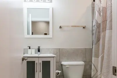 a bathroom with a sink and a mirror and a toilet at Spacious 3-Bed3BathKing BedsTVWasherDryer in Philadelphia