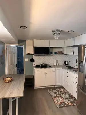 a kitchen with white cabinets and a wooden table at Suhira Hospitality Group in Lansdowne