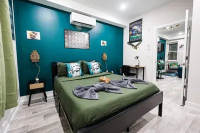 a bedroom with a bed with a blue wall at Perch in Paradise EaglesThemed Escape in Philadelphia