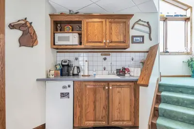 a small kitchen with wooden cabinets and a sink at Clarks Summit Gem w/ Private Yard & Parking in Clarks Summit