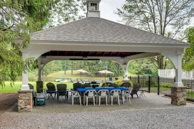 a pavilion with tables and chairs in a park at Fish and Hike Lakeside Poconos Retreat, Unit 4 in Bangor