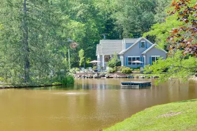 a house sitting on a river with a house at Fish and Hike Lakeside Poconos Retreat, Unit 3 in Bangor