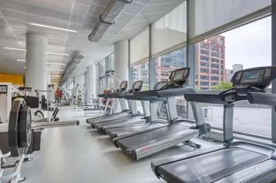 a row of treadmills in a gym at Blueground Hells Kitchen view nr Hudson River NYC-1905 in New York