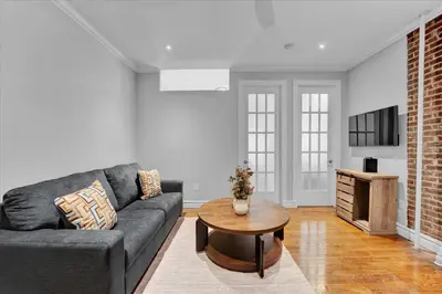 a living room with a couch and a table at Modern 2BR with Private Garden In Gramercy Park in New York