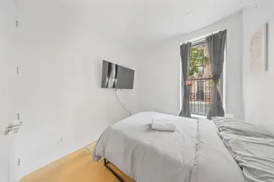 a white bedroom with a bed and a window at Double Room at a shared Apartment near Times Square in New York