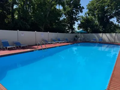 a large swimming pool with chairs and a fence at Spacious 2BR2BA Monthly Discount in Elkins Park