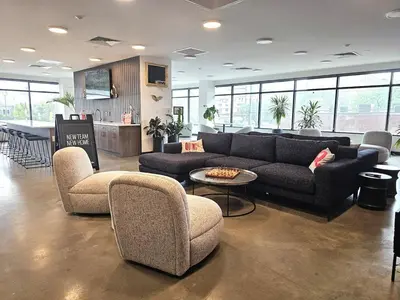 a living room with a couch and chairs and a kitchen at Boutique Studio with Rooftop View and Gym in Philadelphia