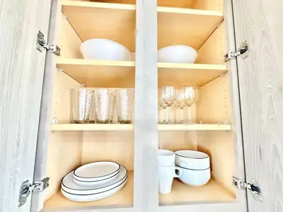 a cupboard with plates and bowls and glasses in it at Philly Central King 1BR with Gym in Philadelphia
