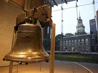a large golden bell in a building with a clock tower at Old City Apt Near Independent Hall and Liberty Bell in Philadelphia