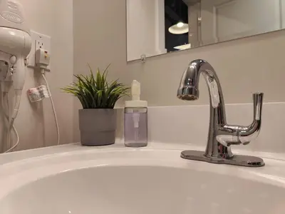 a sink with a bottle of soap next to a faucet at Studio Apt Near Temple Unit with Free Parking for Extended Stays in Philadelphia
