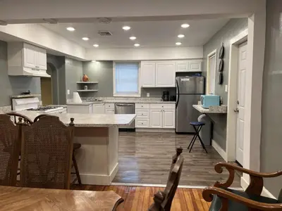 a kitchen with white cabinets and a large island at Relaxing, Spacious Private Room near Binghamton in Johnson City