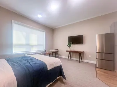 a bedroom with a bed and a large window at 415 Modern Brand New Studio Apartment in Old Bridge