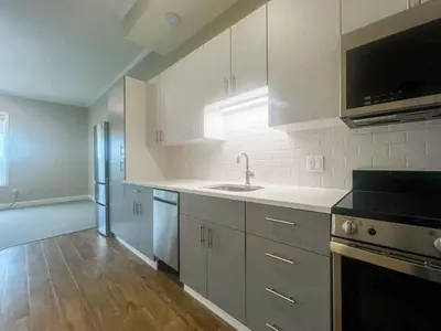 a kitchen with white cabinets and a sink at 414 Modern Brand New Studio Apartment in Old Bridge