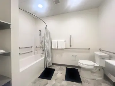 a white bathroom with a toilet and a bath tub at 412 Modern Brand New Studio Apartment in Old Bridge