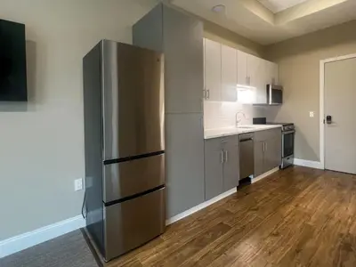 a large kitchen with a stainless steel refrigerator at 408 Modern Brand New Studio Apartment in Old Bridge