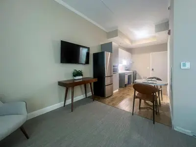 a living room with a kitchen with a table and a refrigerator at 403 Modern Brand New Studio Apartment in Old Bridge
