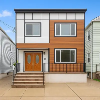 a house with a brown door and stairs at Modern 2BR and Office Near NYC With Parking - Sleeps 6 in Jersey City