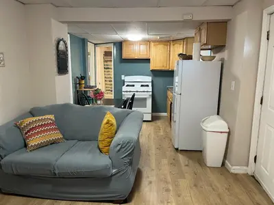 a living room with a couch and a refrigerator at Comfy PR near UHS Wilson and BU in Johnson City