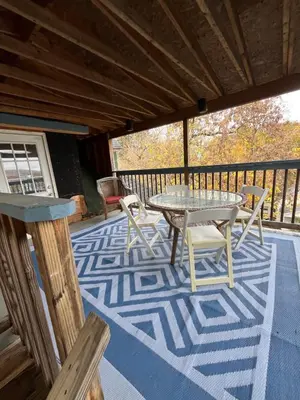 a patio with a table and chairs on a deck at Spacious, Unique PR near Binghamton University in Johnson City