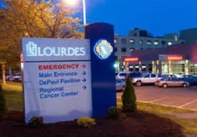 a sign in front of a parking lot with cars at Lovely PR near Lourdes Hospital by Binghamton in Johnson City