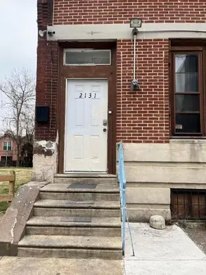 a white door on a brick building with stairs at 2131 queen room With shared Bathroom in Philadelphia