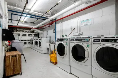 a laundry room with three washing machines in it at Blueground Midtown East rooftop nr Grand Central NYC-2069 in New York