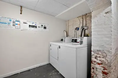 a kitchen with white appliances and a brick wall at Large Studio in Center City that Sleeps 4 with Fast Wifi in Philadelphia