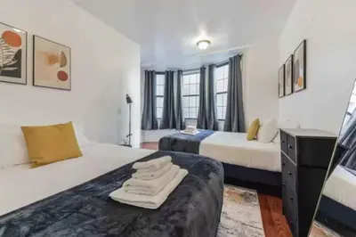 a hotel room with two beds and a desk at 1BR Across Convention Center in Philadelphia