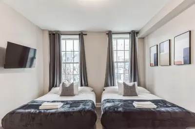 two beds in a room with windows at Bi-Level 2BR Loft in Old City in Philadelphia