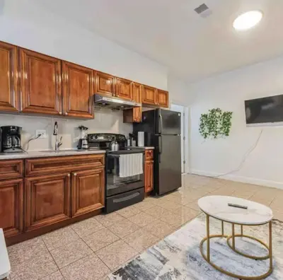 a kitchen with wooden cabinets and a black refrigerator at Across from Convention Center - Sleeps 6 - 3F in Philadelphia