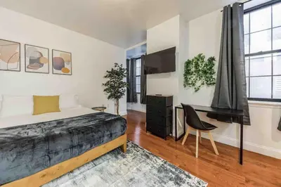 a bedroom with a bed and a desk and a chair at Cozy Studio Across from Convention Center - 3R in Philadelphia