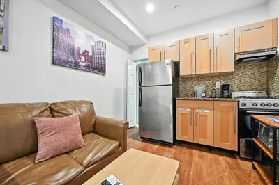 a living room with a couch and a stainless steel refrigerator at Spacious Family Home in Philadelphia in Philadelphia