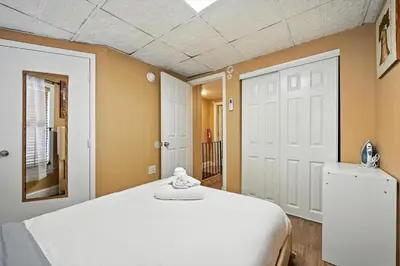 a bedroom with a white bed and a mirror at Spacious Family Home in Philadelphia in Philadelphia