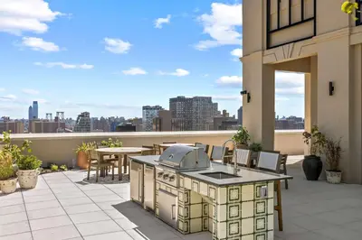 an outdoor kitchen on a patio with a view of the city at Freeman 602 by Rove Travel - Condo with Shared Amenities in New York