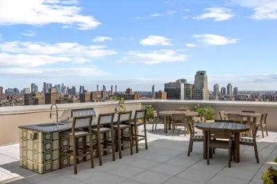 a balcony with tables and chairs and a view of the city at Freeman 603 by Rove Travel - Studio with Shared Amenities in New York