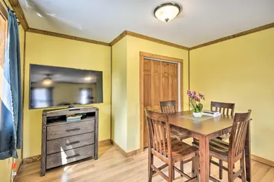 a dining room with a table and a tv at Quadruple Suites At Equestrian House in Pleasant Mount