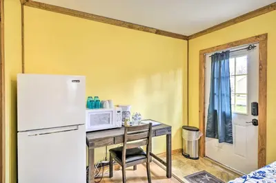 a kitchen with a table with a microwave and a refrigerator at Romantic Escape Cottage and Suites Close to Ski Trails in Pleasant Mount