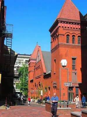 a man standing in front of a red brick building at THE STAGE HOUSE - CITY CENTER THEATER DISTRICT in Lancaster