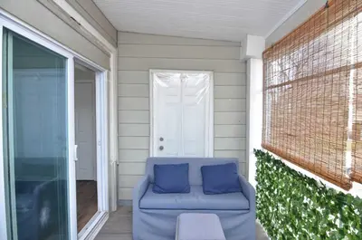 a blue couch sitting on a porch with a door at Cozy Beds with Parking, Laundry - Near RU, RWJ, NJ Transit in Highland Park