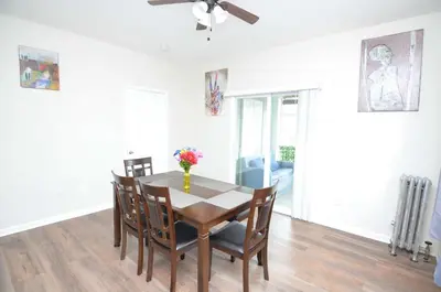 a dining room table with chairs and a vase of flowers on it at Cozy Beds with Parking, Laundry - Near RU, RWJ, NJ Transit in Highland Park