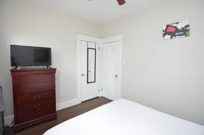 a bedroom with a bed and a tv and a dresser at Spacious Home with Parking, Laundry - Near RU, RWJ, NJ Transit in Highland Park