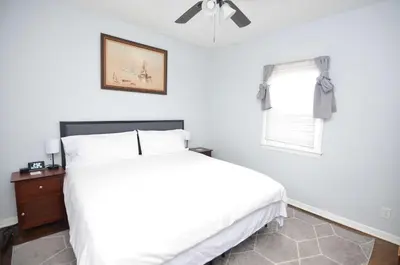 a white bedroom with a bed and a window at Cozy Beds with Parking, Laundry - Near RU, RWJ, NJ Transit in Highland Park