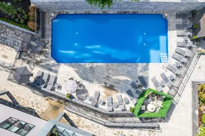 an overhead view of a swimming pool with lounge chairs at Bright Studio Haven - Pool, Gym & Balcony Views in Philadelphia