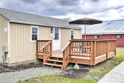 a house with a large deck with an umbrella at Family Cabin and Suite Near Elk Mountain Ski Slopes in Pleasant Mount