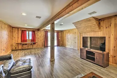 a living room with a couch and a large television at Cozy Cabin and Suite Near Ski Resort in Pleasant Mount
