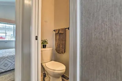 a bathroom with a toilet and a towel at Tranquil Trails Cabin & Suites Near Ski Area in Pleasant Mount