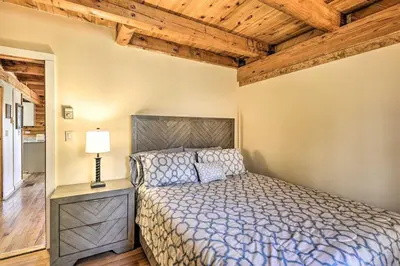 a bedroom with a bed and a lamp and wooden ceilings at Log Cabin and Suite Close to Ski Adventures in Pleasant Mount