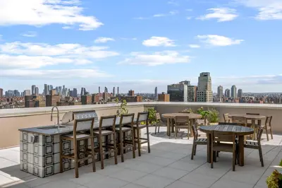 a balcony with tables and chairs and a view of the city at Freeman 501 by Rove Travel - Studio with Shared Amenities in New York