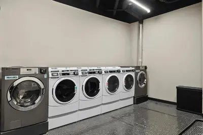 a laundry room with three washing machines in it at Freeman 501 by Rove Travel - Studio with Shared Amenities in New York